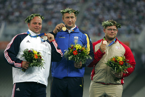OL 2004 i Athen. Kuglestøderen Joachim B. Olsen (th) på podiet med sin bronzemedalje under medaljeoverrækkelsen fredag august 20.2004. I midten guldvinderen Yuriy Belonog, Ukraine og tv. Adam Nelson, USA, der vand sølv. Foto: Lars Møller